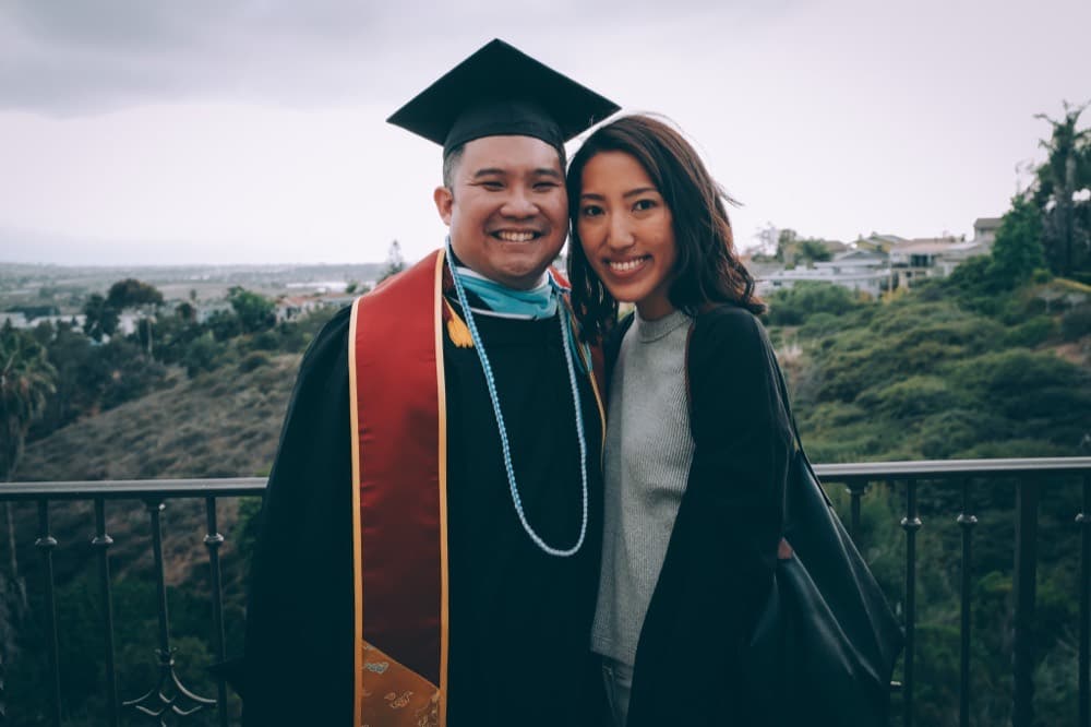 Anthony in cap and gown with an honors stole and lei